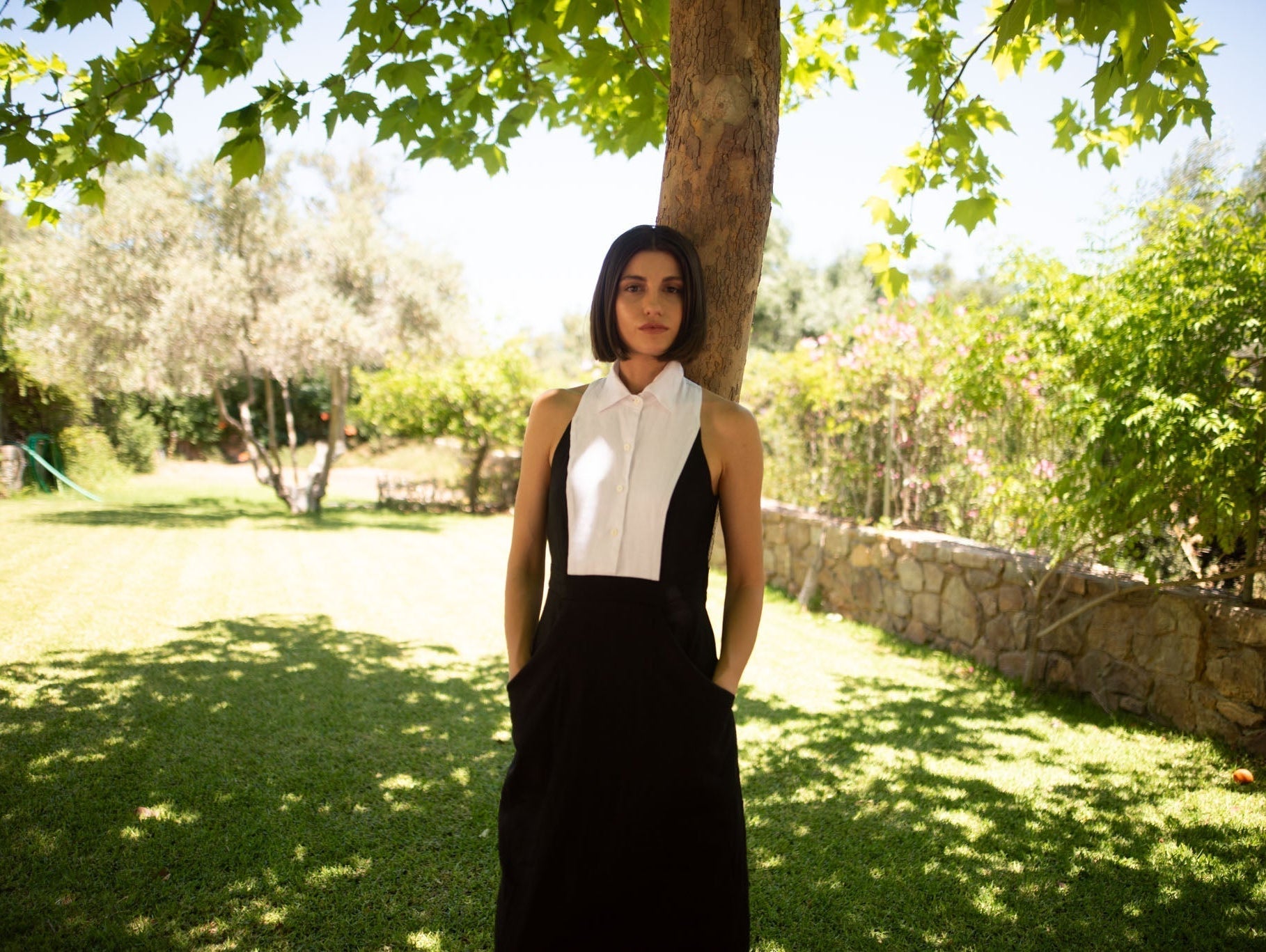 Black Tuxedo linen dress lifestyle photo under a tree, showing how linen fabric holds its shape and fit