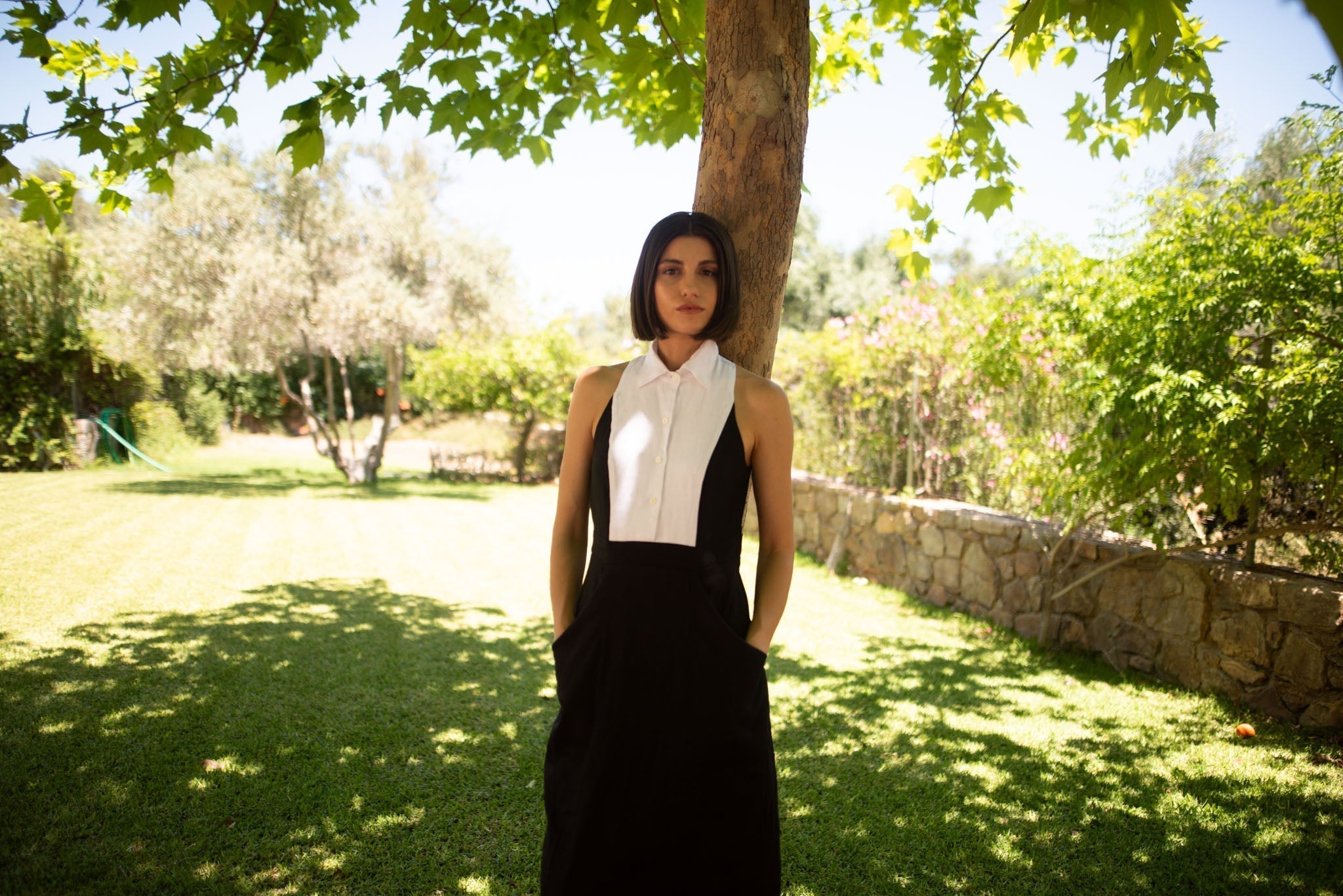 Black Tuxedo linen dress lifestyle photo under a tree, showing how linen fabric holds its shape and fit